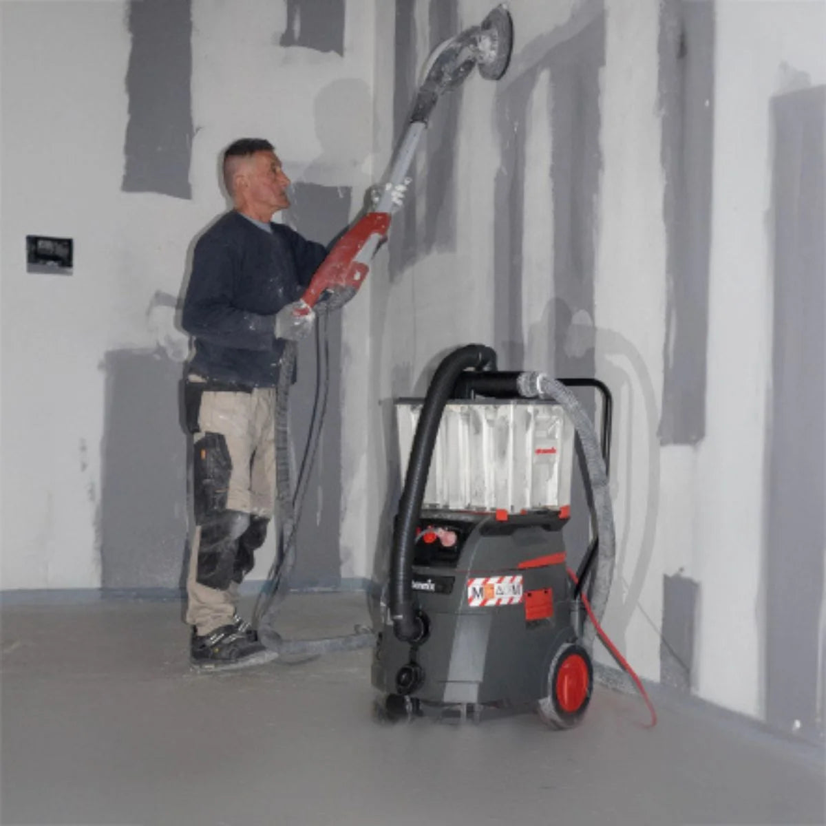 Wall grinder connected to the CS Unitec The Ultimate iPulse Wet/Dry HEPA Vacuum