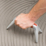 LTHGS Raimondi Fido Ergonomic Support spreading thin set mortar with notched trowel on floor